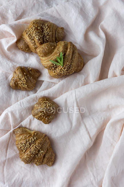 Homemade baked croissants on white fabric — Stock Photo