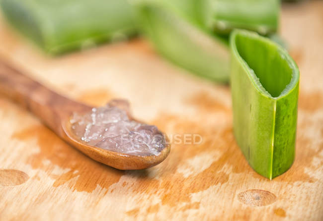 Stücke frischer grüner Aloe Vera mit weißem Fruchtfleisch auf Holzlöffel — Stockfoto