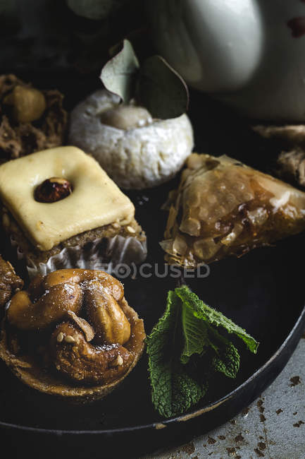 Typical Moroccan sweets with honey and almonds on black plate — Stock Photo