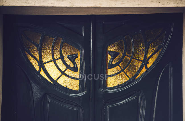 Close-up of black antique doors with ornamental window — Stock Photo