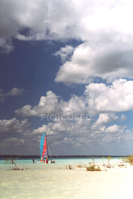 Grupo de personas navegando en bote pequeño mientras descansan en el Caribe Mexicano en día nublado - foto de stock