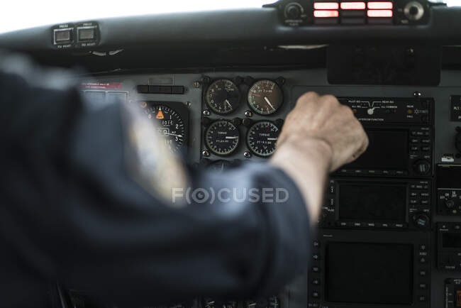 Crop hand of unrecognizable pilot piloting modern aircraft by using control wheel — Stock Photo