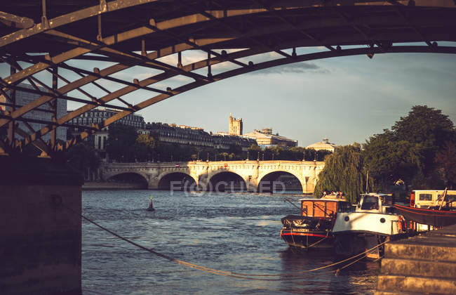 Ponte de pedra velha acima do rio e barcos flutuando perto do aterro, Paris, França — Fotografia de Stock