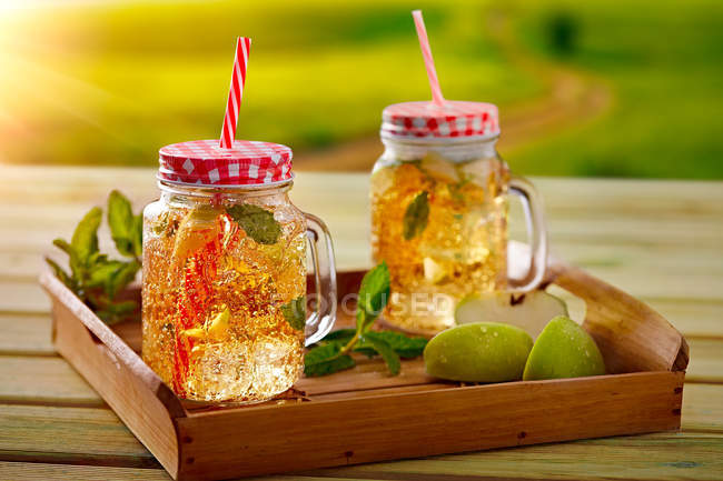 Bandeja de madera con copas de vidrio de limonada fría hecha de lima y menta - foto de stock