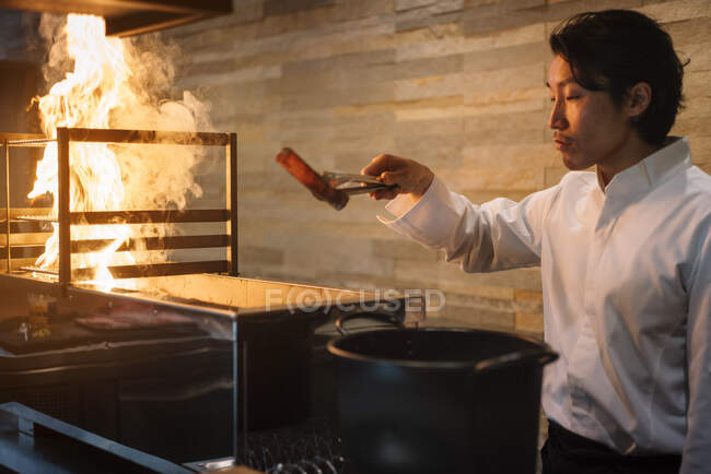 Chef cuisinier au restaurant préparant du charbon — Photo de stock