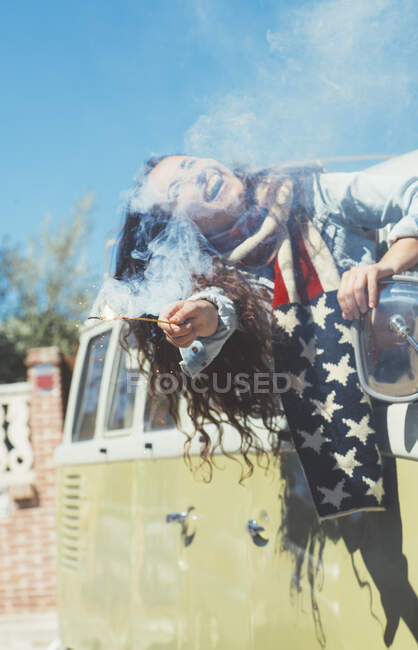 Bruna donna con bengala e sciarpa americana nel vecchio furgone — Foto stock