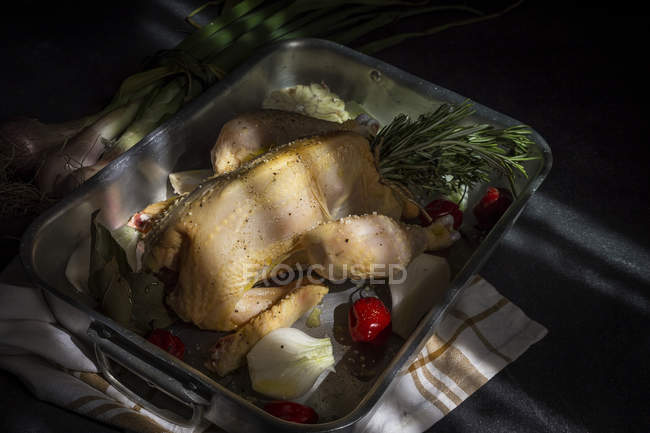 Poulet entier cru prêt à rôtir sur plaque de cuisson avec des ingrédients — Photo de stock
