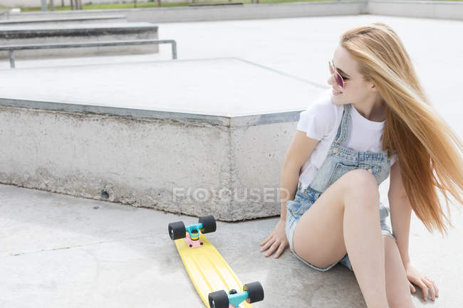 Блондинка funky дівчина сидить на підлозі з Пенні Ради — стокове фото