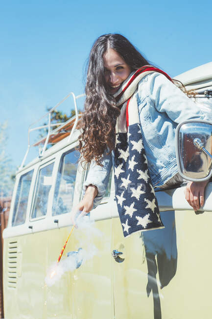 Brunette woman with bengal and American scarf in the old van — Stock Photo