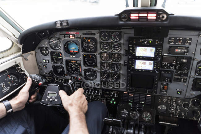 Unrecognizable man in headset piloting plane?alone while sitting in cockpit of modern aircraft — Stock Photo