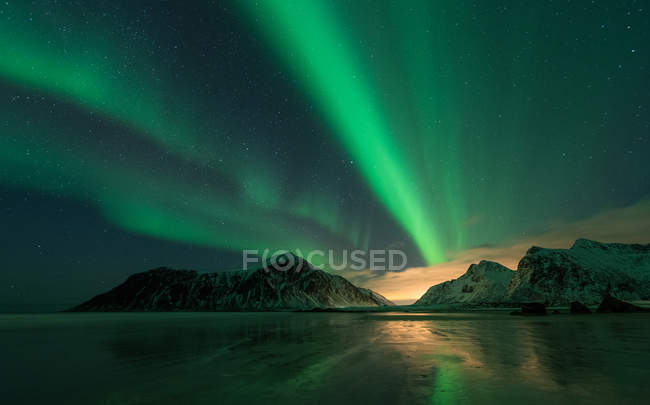 Vista pitoresca das luzes do norte e montanhas nevadas no mar à noite — Fotografia de Stock
