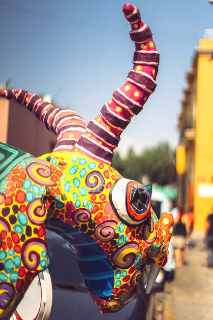 Brillante cabeza de dragón de papel de carnaval caminando por la calle en Oaxaca, México - foto de stock