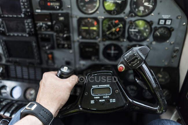 Mão de colheita de piloto irreconhecível pilotando aeronaves modernas usando roda de controle — Fotografia de Stock