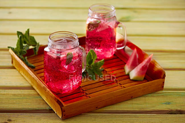 Watermelon lemonade in glass cups on wooden tray — Stock Photo