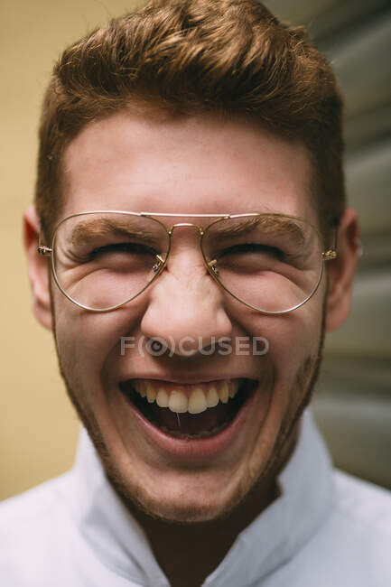 Primer plano de alegre hombre pelirrojo brillante en gafas con estilo mirando a la cámara locamente con emoción. - foto de stock
