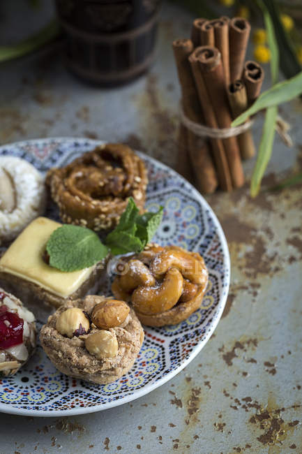 Dulces típicos marroquíes con miel y almendras en bandeja estampada - foto de stock