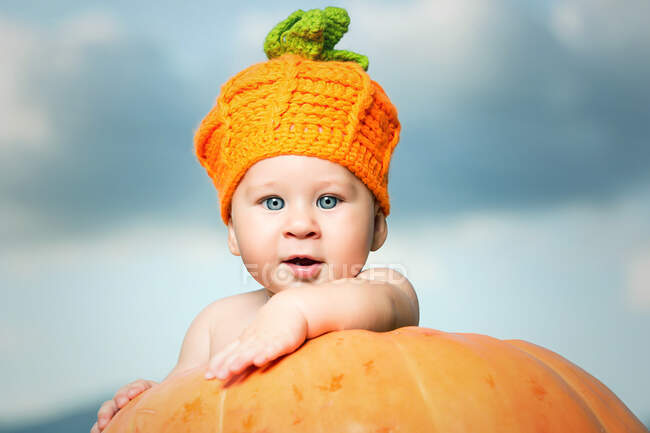 Adorable little kid standing in big pumpkin with the ladder. — Stock Photo