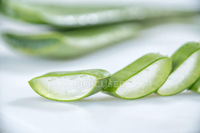 Pezzi di fresco verde Aloe Vera in fila su sfondo bianco — Foto stock