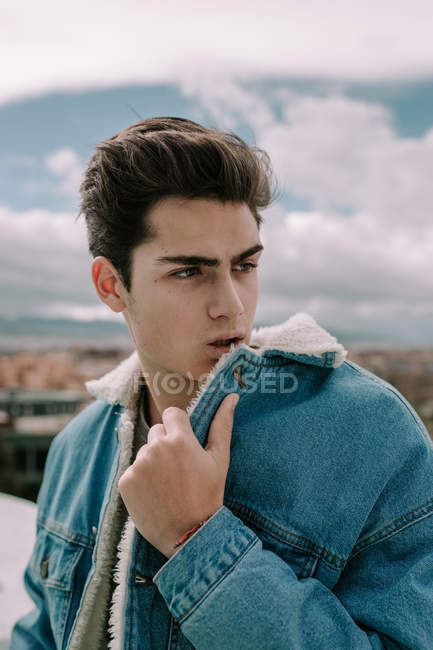 Porträt eines jungen Teenagers in stylischer Jeansjacke, der vor dem Hintergrund der Stadt steht — Stockfoto