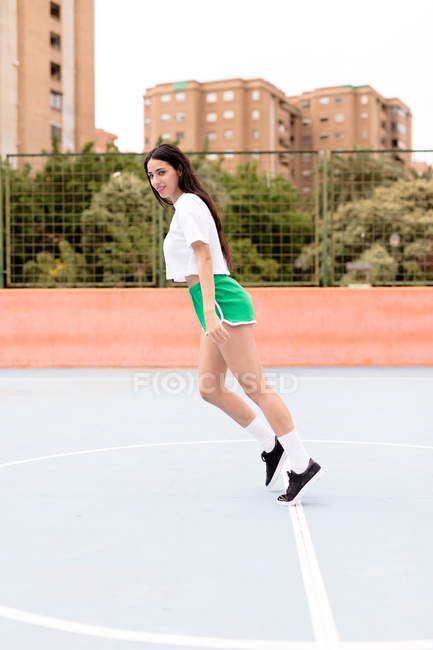 Young woman in sportswear falling forward straight on outdoors sports ground in city — Stock Photo