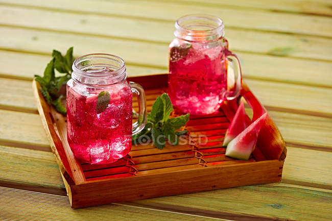 Watermelon lemonade in glass cups on wooden tray — Stock Photo