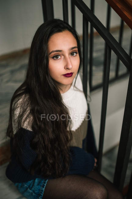 Вдумчивая девочка-подросток, сидящая на лестнице в здании — стоковое фото