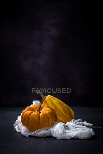 Zucche fresche su panno bianco su sfondo nero — Foto stock