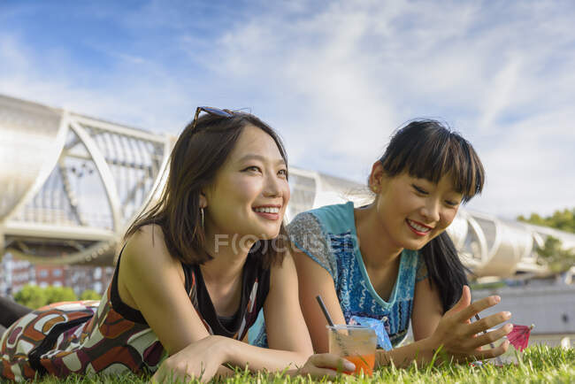 Donne asiatiche sdraiate sull'erba del parco — Foto stock