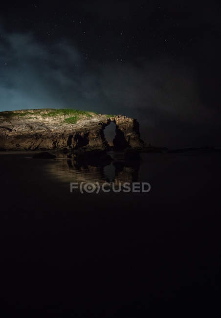 Penhasco arqueado localizado perto do mar calmo à noite na natureza, Astúrias, Espanha — Fotografia de Stock