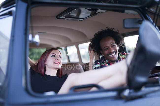 Schöner Afro-Mann genießt die Fahrt in ihrem Oldtimer-Van mit einigen Freunden — Stockfoto