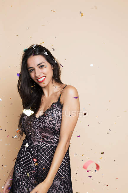 Ritratto di giovane donna felice in abito festivo con stelle filanti — Foto stock