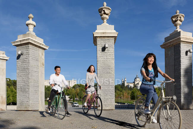 Cheerful Asian people riding bicycles in park — Stock Photo