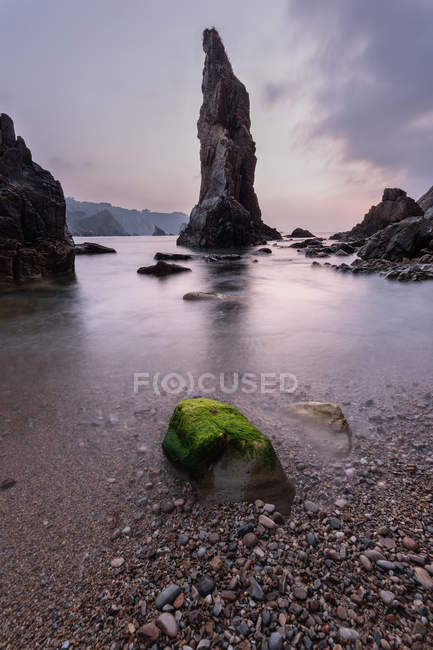 Rocce rocciose sulla riva vicino alla calma acqua di mare al tramonto, Asturie, Spagna — Foto stock