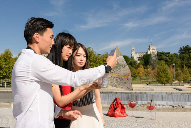 Asian tourists looking at map in street — Stock Photo