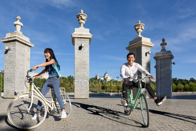 Alegre gente asiática montando bicicletas en el parque - foto de stock