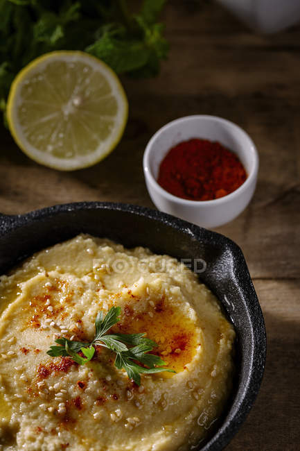 Hausgemachter Kichererbsenhumus mit Paprika und Zitrone auf Holztisch — Stockfoto