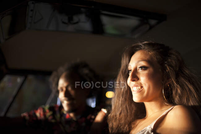 Красива і молода дівчина брюнетка насолоджується поїздкою у старовинному фургоні з деякими друзями — стокове фото
