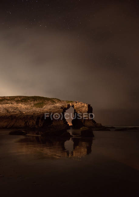 Gewölbte Klippe in der Nähe ruhigen Meeres in der Nacht in der Natur, Asturien, Spanien — Stockfoto