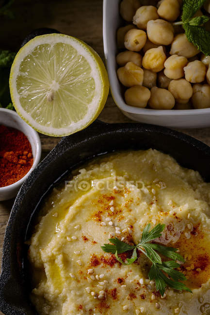 Homemade chickpea humus with cucumber and carrot on wooden table — Stock Photo