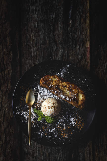 French toast con gelato alla vaniglia, cannella e menta su piatto nero — Foto stock