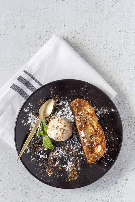 French toast with vanilla ice cream, cinnamon and mint on black plate — Stock Photo