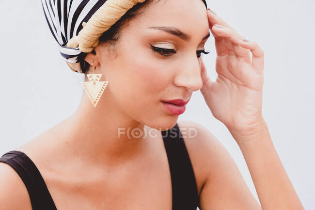 Mujer joven en pañuelo en la cabeza de pie en la azotea - foto de stock