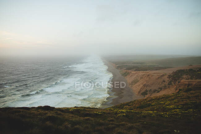 Onde schiumose di mare bello che ondeggiano vicino alla riva di Point Reyes durante l'alba stupefacente in California — Foto stock