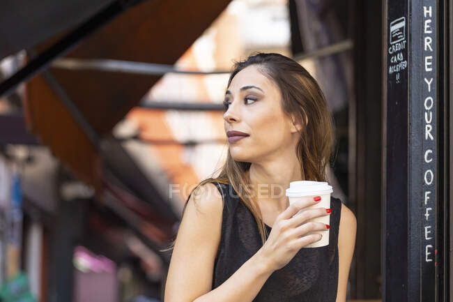 Donna con bevanda vicino caffè all'aperto — Foto stock