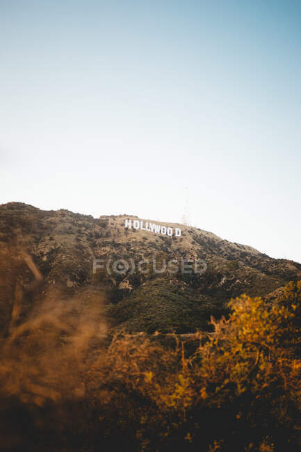 Прекрасный вид на знаменитый голливудский знак, расположенный на удивительной горе против ясного голубого неба в Лос-Анджелесе, Калифорния — стоковое фото