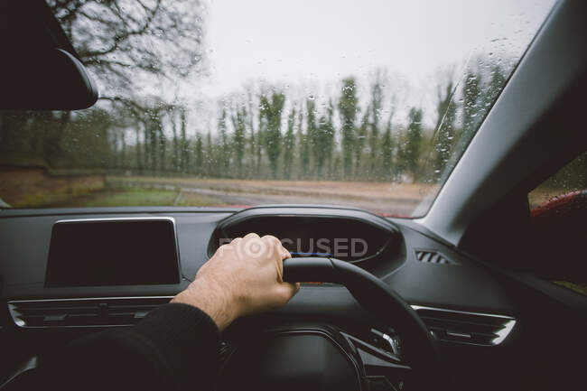Crop man driving car in countryside — Stock Photo