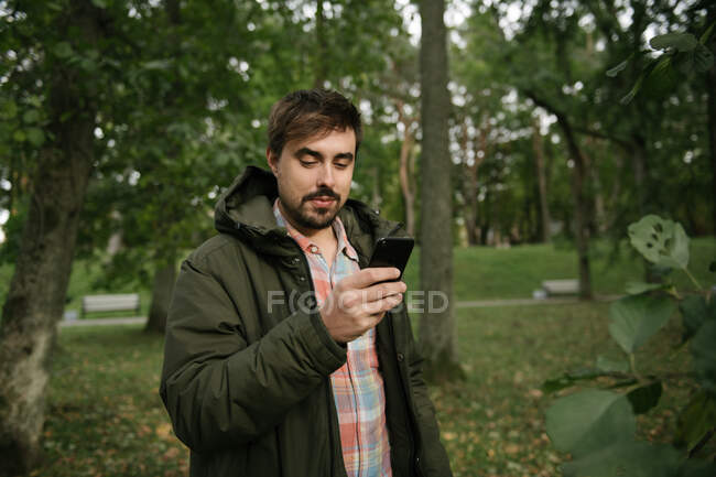 Людина в лісі з мобільним телефоном — стокове фото
