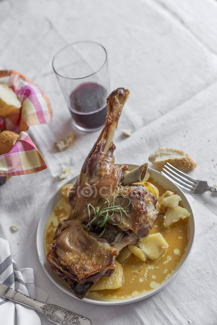 Roasted lamb with potatoes served on plate on white tablecloth — Stock Photo