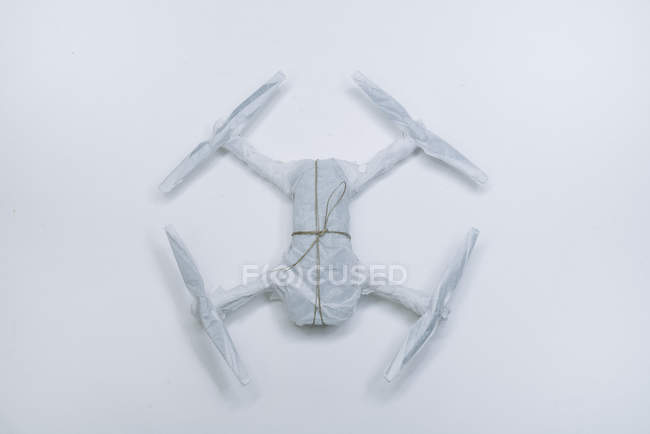 Drone enveloppé comme cadeau de Noël avec ficelle sur fond blanc — Photo de stock