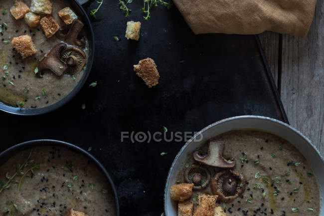 Pilzcremesuppe mit Croutons in Schüsseln auf dunklem Hintergrund — Stockfoto